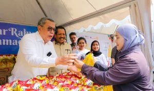 Walikota Tangsel Benyamin Dafnie saat menjaga dan melayani warga pembeli disalah satu stand bazar murah