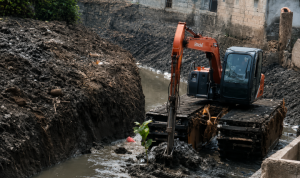 Plang imbauan larangan membuang sampah sembarangan yang terpasang di dekat area aliran sungai.