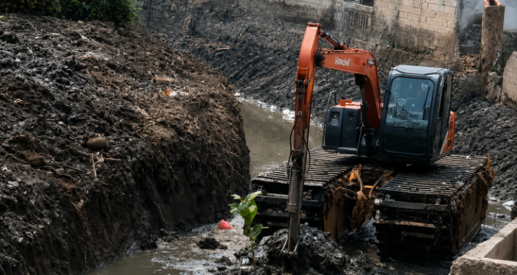 Plang imbauan larangan membuang sampah sembarangan yang terpasang di dekat area aliran sungai.