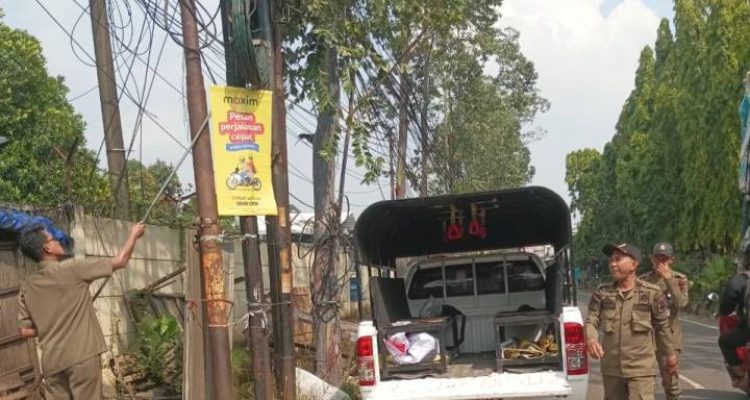 Petugas Trantib Jatiuwung menertibkan spanduk ilegal dan mengedukasi PKL