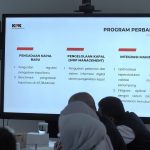 Suasana antrean kendaraan dan proses pemindaian tiket di gerbang boarding pelabuhan penyeberangan.