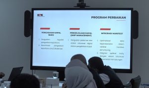 GSN RESEARCH Suasana antrean kendaraan dan proses pemindaian tiket di gerbang boarding pelabuhan penyeberangan.