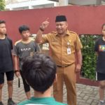 Foto Kadispora Kota Tangerang Kaonang saat meninjau langsung tes fisik atlet PPLPD di GOR Nambo Jaya dengan latar belakang atlet yang sedang berlari.