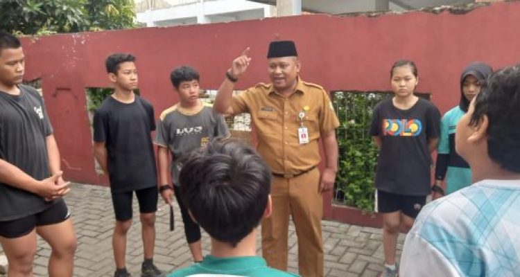 Foto Kadispora Kota Tangerang Kaonang saat meninjau langsung tes fisik atlet PPLPD di GOR Nambo Jaya dengan latar belakang atlet yang sedang berlari.