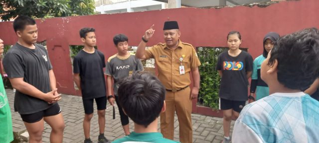 Foto Kadispora Kota Tangerang Kaonang saat meninjau langsung tes fisik atlet PPLPD di GOR Nambo Jaya dengan latar belakang atlet yang sedang berlari.